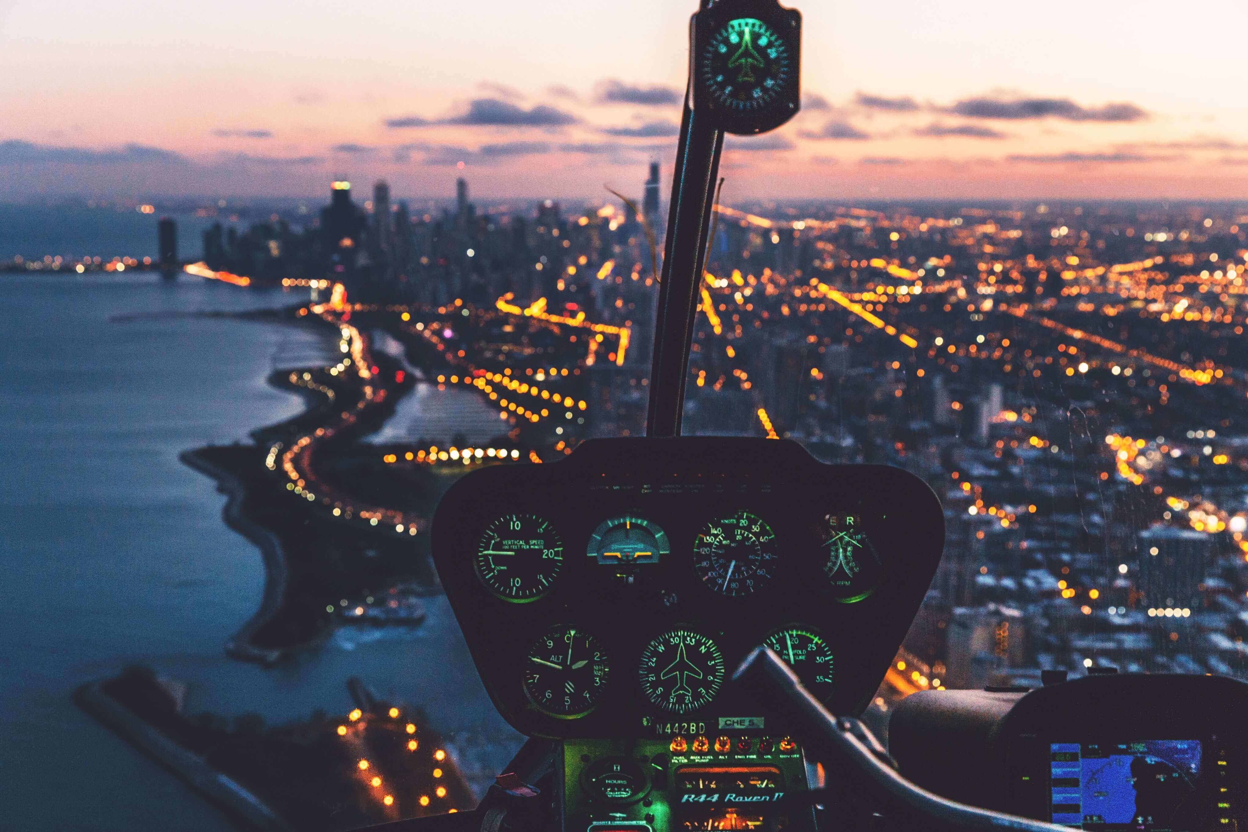 view from helicopter cockpit over city lights