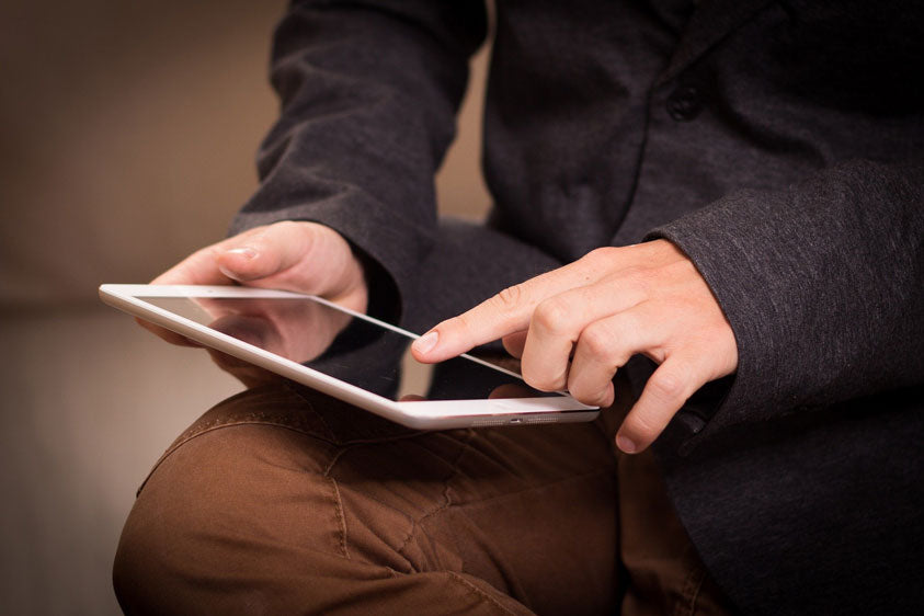 man in brown pants holding an iPad